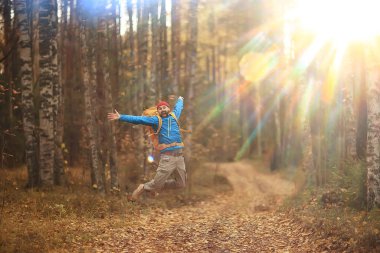 Sırt çantasıyla sonbahar yürüyüşü, güneş ışınları, sonbahar manzarası, gün batımının ışıltısı...