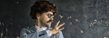 Gözlüklü şık bıyıklı hippi, klasik bir ceketi temizliyor, tozunu alıyor..