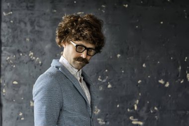 Klasik takım elbiseli, klasik gözlüklü, kıvırcık hippi portresi, uzun saçlı bıyıklı adam.