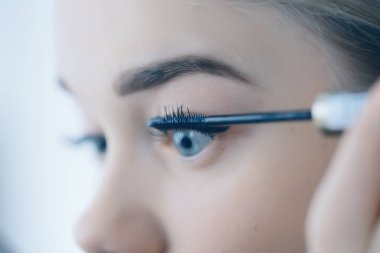 Kirpikli kız, genç güzel sarışın kirpikleri boyuyor, sabahları evde maskara sürüyor.