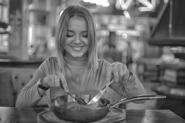 Avrupa restoranındaki öğle yemeği kızı, güzel masa düzenlemesi, yemek yerken poz veren genç manken.