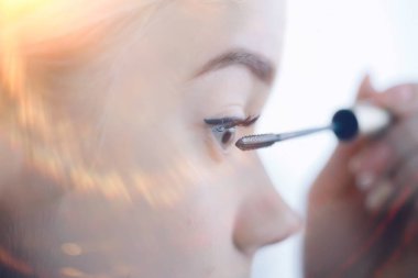 Kirpikli kız, genç güzel sarışın kirpikleri boyuyor, sabahları evde maskara sürüyor.