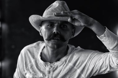 Vahşi Batı 'nın stilize edilmiş klasik portresi, bıyıklı tehlikeli suçlu, yüzünde bıyıklı.