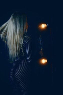 Seksi sarışın kız kadehten şampanya içiyor. Akşam gösterişli bir portreden.