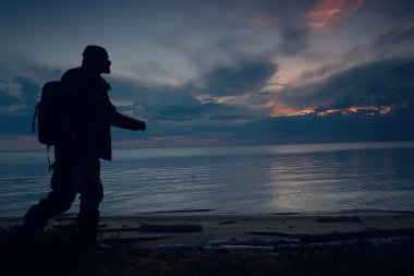 Gölün kenarında gezgin bir adam, kampanyadaki bir adamın silueti, faaliyet