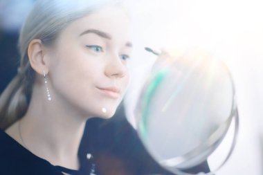 Kirpikli kız, genç güzel sarışın kirpikleri boyuyor, sabahları evde maskara sürüyor.