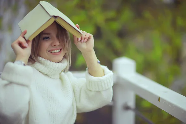 绿树书女孩春天 年轻漂亮的女孩读一本关于阳台季节的书 — 图库照片