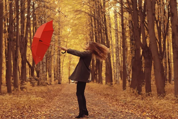傘を持って秋の公園で踊る若い女性は 傘を持って回転し 黄色の10月公園で秋の散歩 — ストック写真