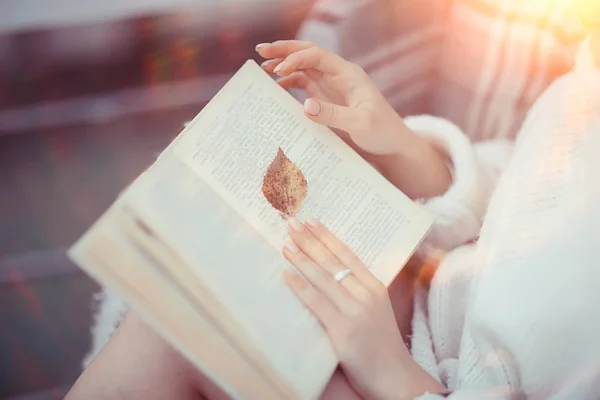 Κορίτσι Ένα Πλεκτό Πουλόβερ Διαβάζει Ένα Βιβλίο Στη Βεράντα Του — Φωτογραφία Αρχείου