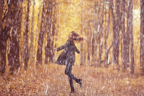 autumn rain woman, beautiful model in the rain in a city park, autumn warm tones, yellow leaves, autumn weather concept