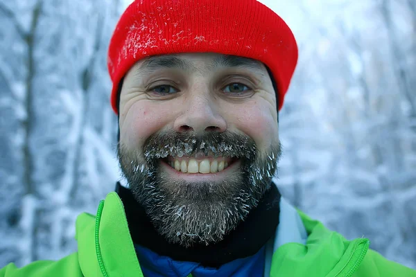 beard in hoarfrost, portrait of a young bearded guy, seasonal outdoor activities in winter in Scandinavia, Norwegian adventure