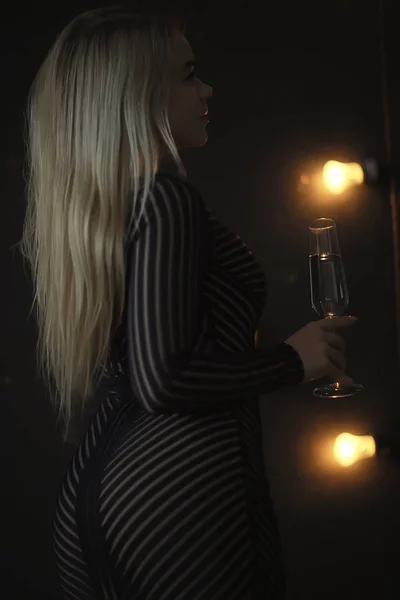 性感金发女孩用杯子喝香槟 夜晚迷人的肖像 — 图库照片