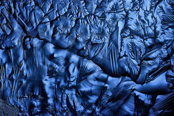 blue ice glass background, abstract texture of the surface of the ice on the glass, frozen seasonal water