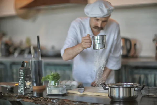 french chef in the kitchen preparing food, cooking, haute cuisine, man with mustache