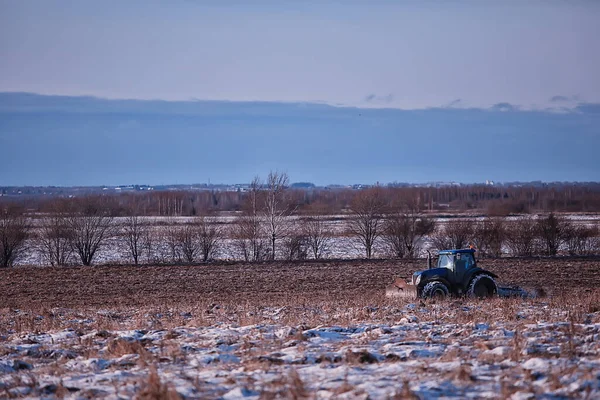 tractor in the field arable land winter agribusiness landscape seasonal work in a snowy field