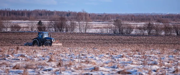 tractor in the field arable land winter agribusiness landscape seasonal work in a snowy field