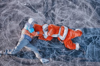 Adam Noel Baba 'dan hediyeler alıyor, gölün buzunda kayıyor, Noel Baba' yı soyuyor.