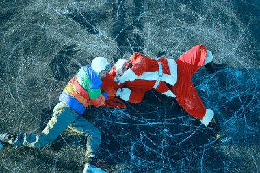 Adam Noel Baba 'dan hediyeler alıyor, gölün buzunda kayıyor, Noel Baba' yı soyuyor.