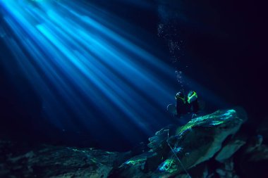 Yucatan Cenote 'nin sualtı mağarası, yer altındaki sarkıtların karanlık manzarası, dalgıç