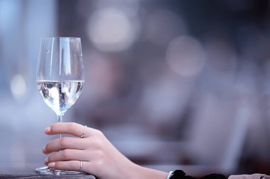 Açık bir kafede beyaz şarap kadehi, bir restoranda bahar manzarası.