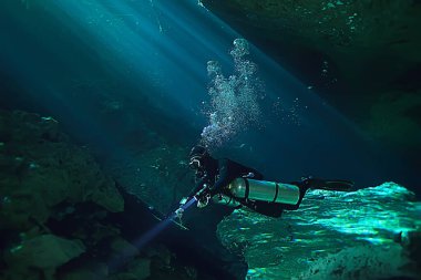 Yucatan Cenote 'nin sualtı mağarası, yer altındaki sarkıtların karanlık manzarası, dalgıç