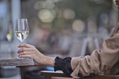 Açık bir kafede beyaz şarap kadehi, bir restoranda bahar manzarası.