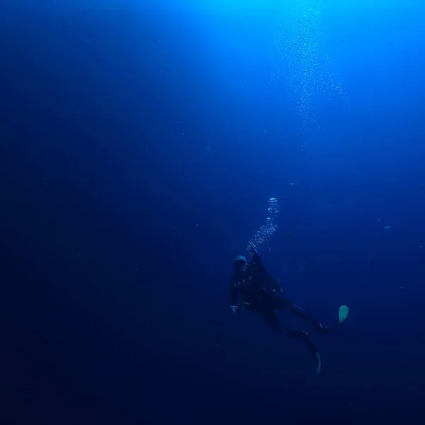 diver breathes air under water bubbles, releases gas, landscape underwater depth