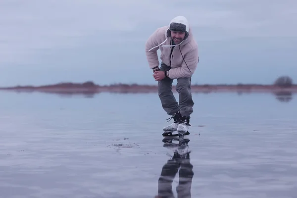 one guy skates on the ice of a frozen lake, nature landscape, man outdoor sports