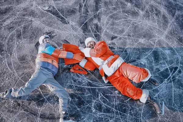 Adam Noel Baba 'dan hediyeler alıyor, gölün buzunda kayıyor, Noel Baba' yı soyuyor.