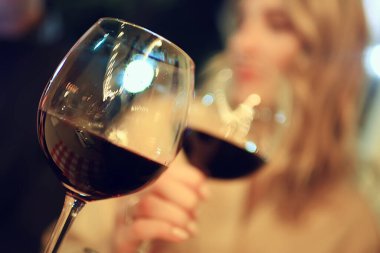 Bir bardak tost çene çene, bir kafede beyaz şarap kadehleriyle eller