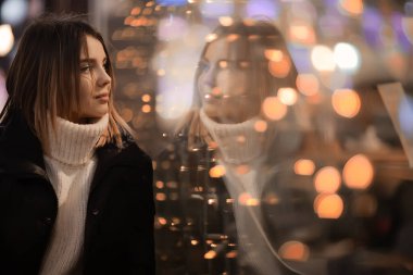 girl christmas lights evening decorated city, a young model on the background of urban decorations and garlands, night city lights clipart