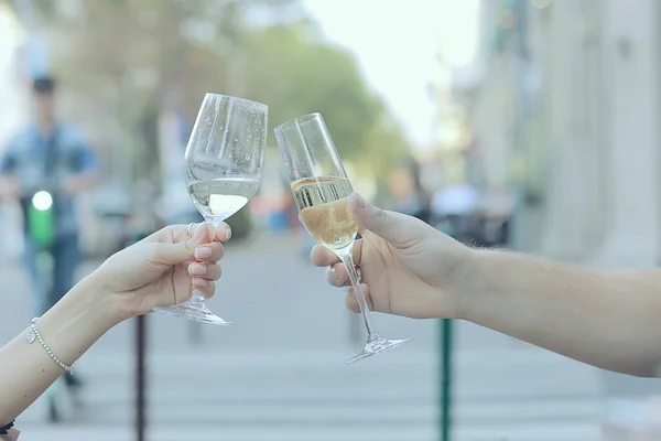 glasses of toast chin chin, hands with glasses of white wine in a street cafe