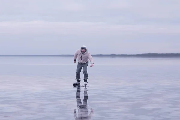 one guy skates on the ice of a frozen lake, nature landscape, man outdoor sports