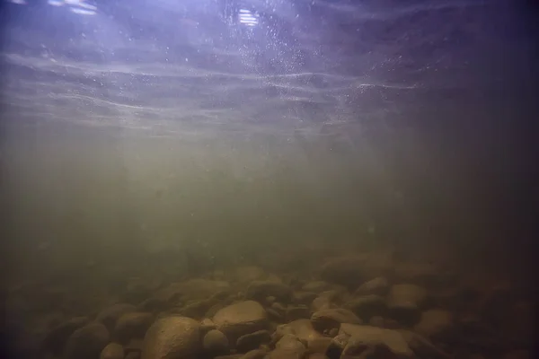 stones at the bottom underwater landscape, abstract blurred under water background