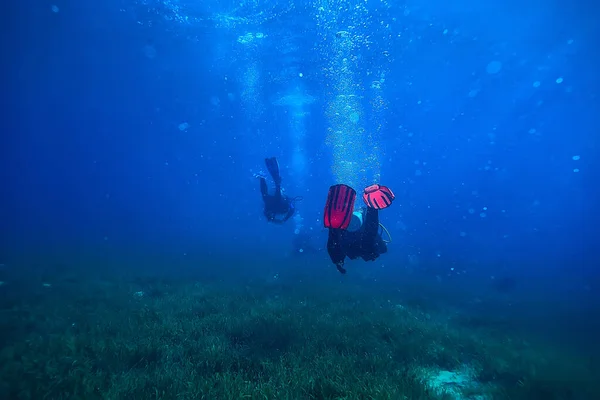 diver flippers view from the back underwater, underwater view of the back of a person swimming with scuba diving