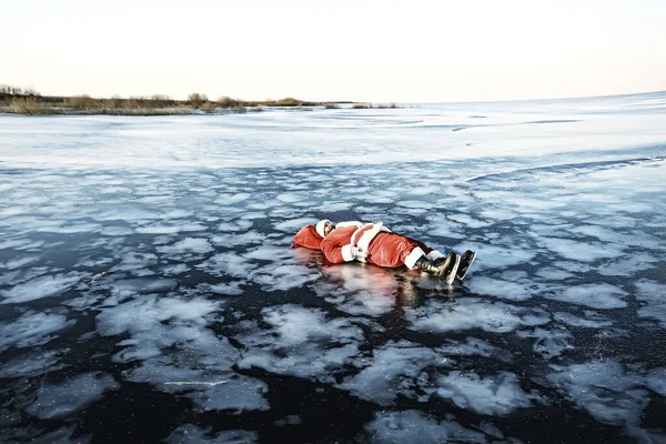 サンタクロースは湖の氷の上でスケート 横になり サンタ負け犬 — ストック写真