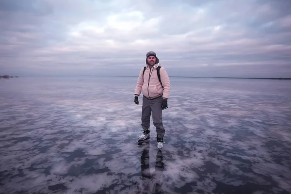 one guy skates on the ice of a frozen lake, nature landscape, man outdoor sports