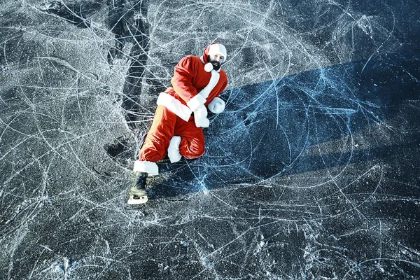 Santa Claus skating on the ice of the lake, slipped, lies down, Santa loser