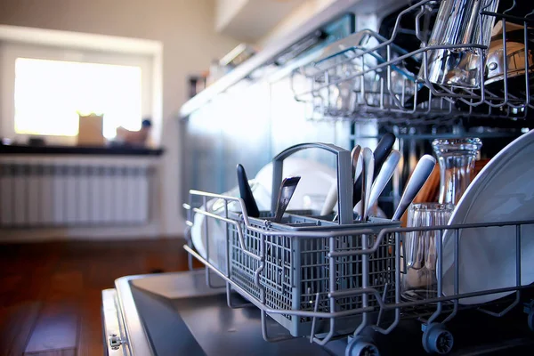 open dishwasher in the kitchen, dishes inside, clean plates in the kitchen lifestyle view