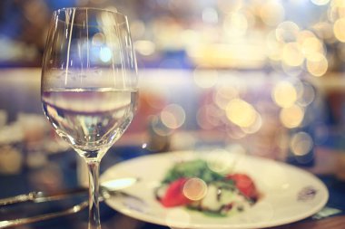 Lokantada bir akşam, bulanık bir arka plan, bokeh, alkol konsepti, bir barda şarap kadehi.