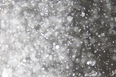 soyut arkaplan, siyah üzerine beyaz bokeh düşen kar sisi görünümünü örtüyor