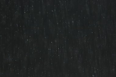 soyut arkaplan, siyah üzerine beyaz bokeh düşen kar sisi görünümünü örtüyor