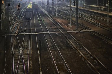 Demiryolu, sonbaharda tren istasyonundaki gece manzarasını izler.