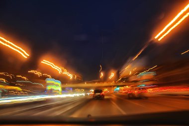Gece şehrinin soyut görüntüsü bir araba penceresinden bulanık, şehirde trafik...