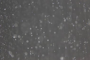 soyut arkaplan, siyah üzerine beyaz bokeh düşen kar sisi görünümünü örtüyor