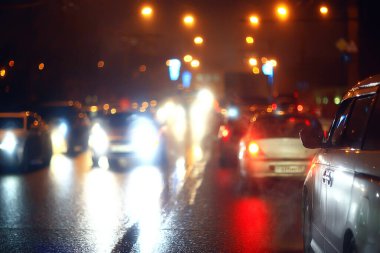 Gece şehrinin soyut görüntüsü bir araba penceresinden bulanık, şehirde trafik...