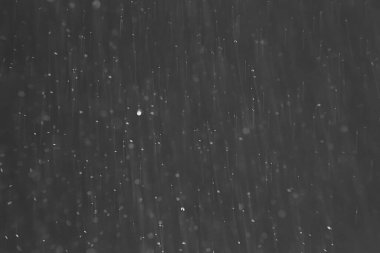 soyut arkaplan, siyah üzerine beyaz bokeh düşen kar sisi görünümünü örtüyor