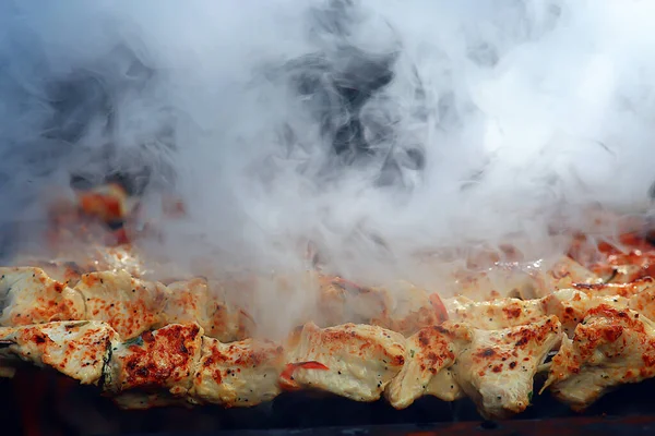 barbecue meat on coals, smoke smoked on iron skewers, fresh meat background