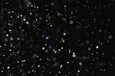 soyut arkaplan, siyah üzerine beyaz bokeh düşen kar sisi görünümünü örtüyor