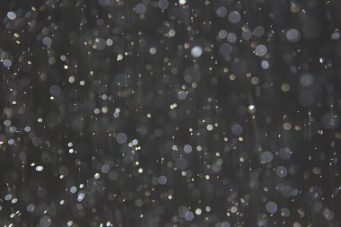 soyut arkaplan, siyah üzerine beyaz bokeh düşen kar sisi görünümünü örtüyor